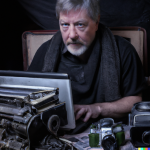DALL·E 2022-09-29 13.49.06 - Portrait of Retro-Grouch, an angry old man typing at his laptop surrounded by a collection of vintage film cameras, photorealistic portrait photograph.png